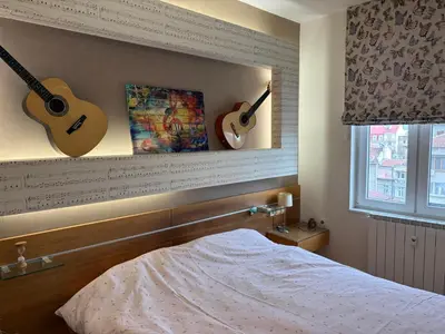 a bedroom with two guitars on the wall and a bed at Vitosha Sunrise in Sofia