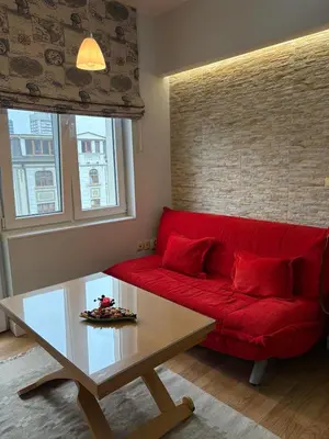 a red couch in a living room with a coffee table at City Sunrise in Sofia