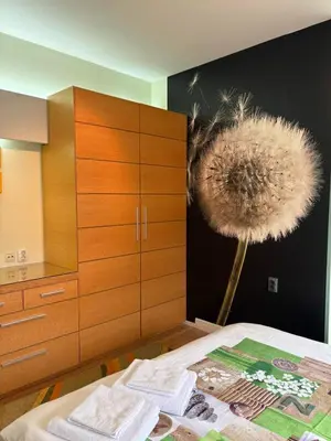 a bedroom with a dandelion painting on the wall at City Sunrise in Sofia