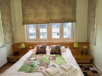 a large bed in a bedroom with a window at City Sunrise in Sofia