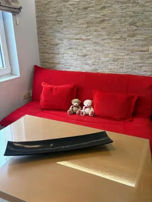 a red couch with two teddy bears sitting on it at City Sunrise in Sofia
