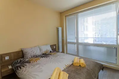 a bedroom with a bed and a large window at Cherkovna Residence Apartment plus GARAGE !!! in Sofia