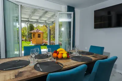 a dining room table with a bowl of fruit on it at ENEVI Guest Houses-Къщи за гости Еневи in Sandanski
