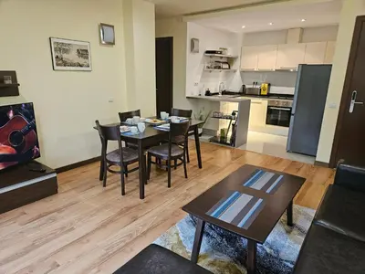 a living room with a table and chairs and a kitchen at TERRA COMPLEX B4 - Private apartment - Golf, Skiing & SPA in Bansko