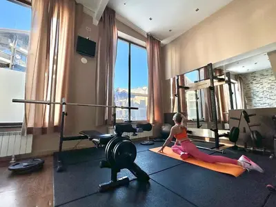 a woman sitting on a yoga mat in a gym at TERRA COMPLEX B4 - Private apartment - Golf, Skiing & SPA in Bansko