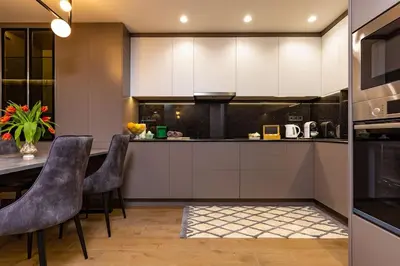 a kitchen with white cabinets and a table with chairs at Central Victoria Home 2-bedroom apt in Plovdiv