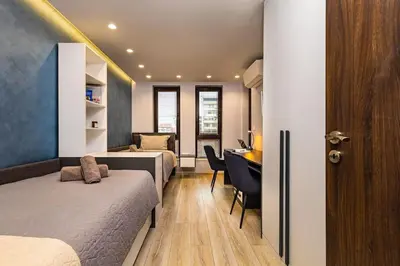 a bedroom with two beds and a desk in a room at Central Victoria Home 2-bedroom apt in Plovdiv