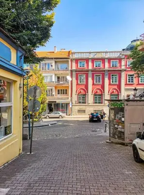 a street in front of a large red building at La Primavera Spacious Apartment in Plovdiv