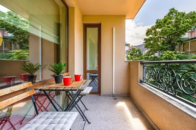 an outdoor patio with a table and chairs on a balcony at Beautiful apartment in the heart of Plovdiv in Plovdiv