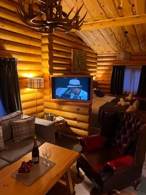 a living room with a television in a log cabin at Kare Luxury Chalets in Tsigov Chark