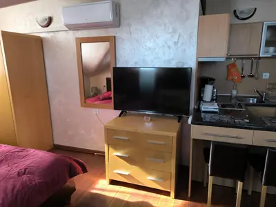 a kitchen with a television on a dresser with a mirror at Апартамент-студио Б4-4-1 Божурленд in Bansko