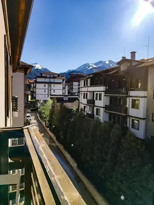 a view from a balcony of buildings with snow covered mountains at GALA 2Bedroom Apartment 200m from Gondola in Bansko