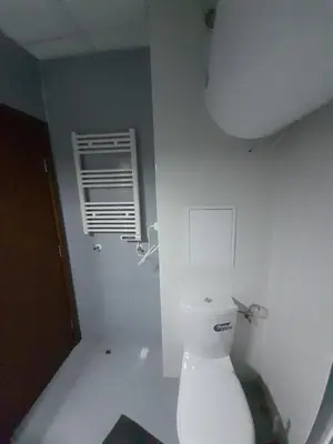 a white bathroom with a toilet and a window at lux apartament К602 in Bansko