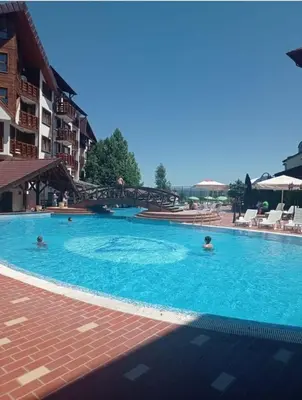 a large swimming pool with people in the water at lux apartament К602 in Bansko