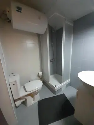 a white bathroom with a toilet and a shower at lux apartament К602 in Bansko