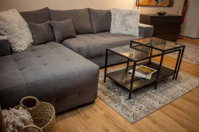 a living room with a gray couch and a glass table at EVIAS Apartment in Sandanski