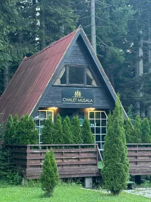 a house with a red roof with a sign on it at Chalet Musala Borovets by BookVillaBG in Borovets