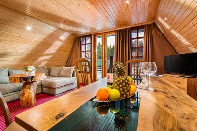 a living room with a table with a bowl of fruit on it at Chalet Musala Borovets by BookVillaBG in Borovets