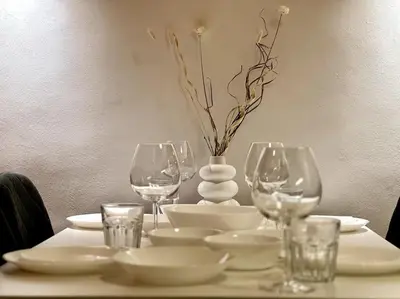 a table with wine glasses and a vase on it at Sofia Sweet Spot: Central & Cozy in Sofia