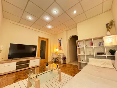 a living room with a couch and a flat screen tv at Cozy and quiet central apartment in Sofia