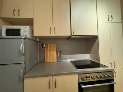 a kitchen with white cabinets and a stove top oven at Cozy and quiet central apartment in Sofia