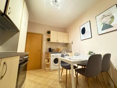 a kitchen with a table and chairs in a room at Cozy and quiet central apartment in Sofia