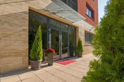 a entrance to a building with potted plants in front at Hotel Calipso Hotel in Sofia