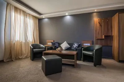 a waiting room with chairs and a couch and a table at Hotel Calipso Hotel in Sofia
