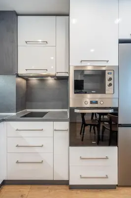 a kitchen with white cabinets and a microwave and a table at Harmony Suite in Sofia