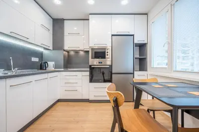 a kitchen with white cabinets and a table with chairs at Harmony Suite in Sofia