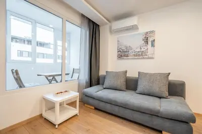 a living room with a couch and a window at Harmony Suite in Sofia