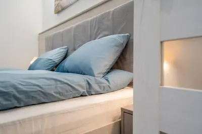 a bed with blue pillows sitting on a bench at Harmony Suite in Sofia