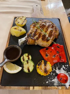 a meal of meat and vegetables on a tray at The Castle Mountain Apartments in Pamporovo