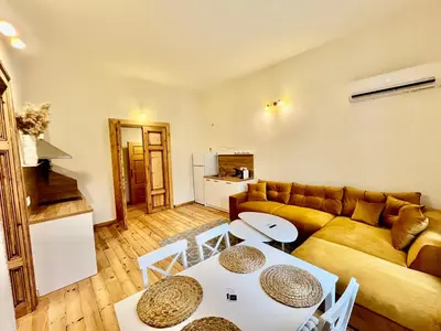 a living room with a couch and a table and chairs at SKYLER VINTAGE APARTMENTS in Plovdiv