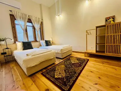 two beds in a room with wooden floors at SKYLER VINTAGE APARTMENTS in Plovdiv