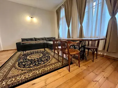 a living room with a couch and a table and chairs at SKYLER VINTAGE APARTMENTS in Plovdiv