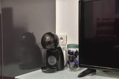 a black coffee maker next to a computer monitor at Tsar Simeon 65 Studio (With Parking space) in Sofia