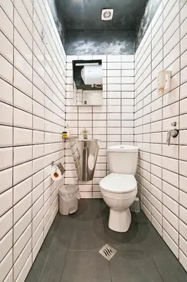a bathroom with a toilet in a white tiled wall at Tsar Simeon 65 Studio (With Parking space) in Sofia
