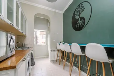 a kitchen with a bar with white stools at 2 Designer Apartments Seconds Away From Тhe Main Street, FREE Parking in Sofia