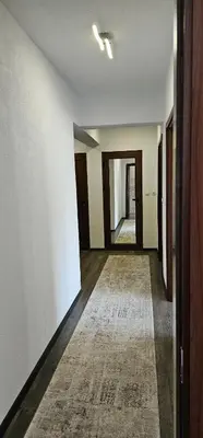 an empty hallway with white walls and a rug at Д и В 3 - D & V 3 Apartment in Sandanski