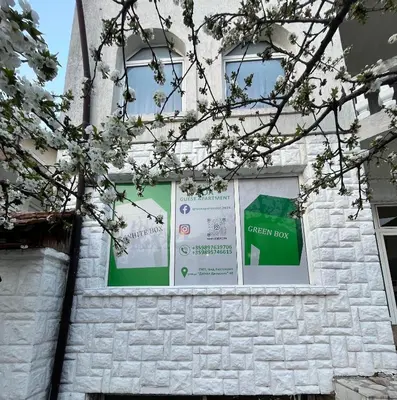 a window of a building with a green day sign at WhiteBoxApartment in Kyustendil