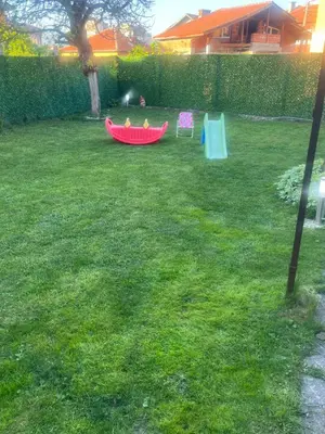a child is playing in a red boat in a yard at WhiteBoxApartment in Kyustendil