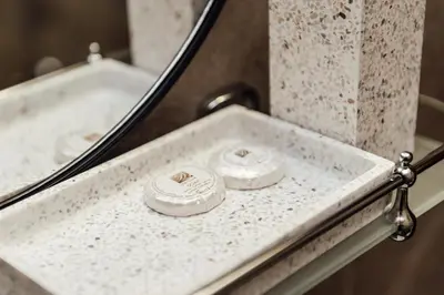 a bathroom sink with two rings in front of a mirror at Къщи за гости БРИК in Sapareva Banya