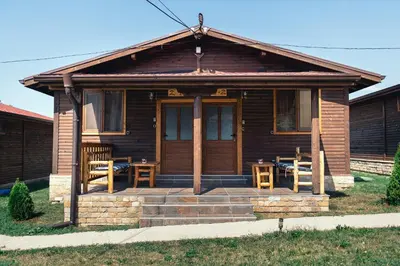 a small wooden house with a porch and a patio at Къщи за гости БРИК in Sapareva Banya