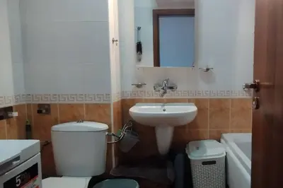 a bathroom with a sink and a toilet and a mirror at 2BR mountain view, SPA, parking, ski piste in Bansko