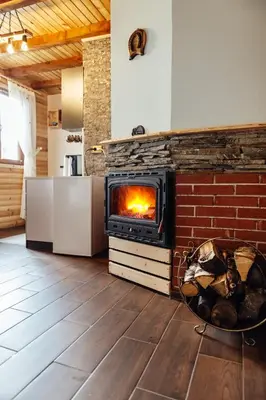 a fireplace in a living room with a stove at Къщи за гости БРИК in Sapareva Banya