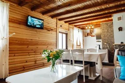 a dining room with a table with a vase of flowers at Къщи за гости БРИК in Sapareva Banya