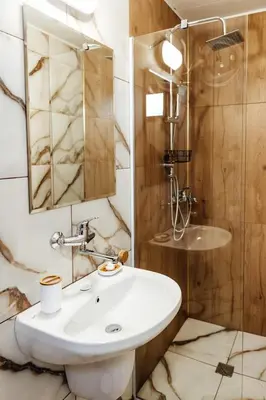 a bathroom with a white sink and a shower at Къщи за гости БРИК in Sapareva Banya