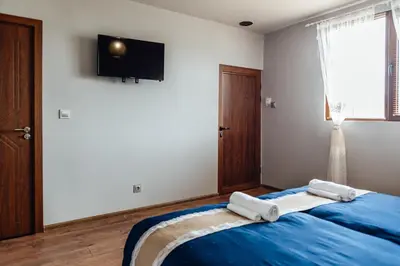 a bedroom with a bed with two towels on it at Къщи за гости БРИК in Sapareva Banya