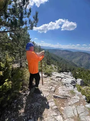 a man standing on the side of a mountain at Хижа Марциганица in Asenovgrad